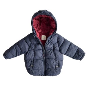 Doudoune noire, intérieur bordeaux, et fourré en polaire. La doudoune comporte une capuche et deux poches latérales à l'avant avec un bouton pression. Le manteau comporte une fermeture zippé. Zara, 2/3 ans, d'occasion