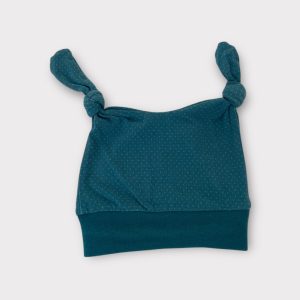 Bonnet bébé turquoise à petits pois, avec deux nœuds sur le dessus et bande en maille. Seconde main.