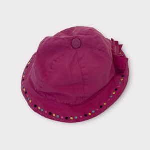 Chapeau bébé fuchsia avec petit bord décoré de pois colorés et nœud à l’arrière. Seconde main.