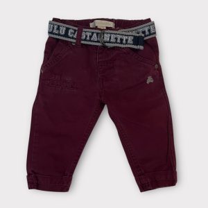 Pantalon pour bébé couleur lie-de-vin avec ceinture grise à inscription, revers aux chevilles et broderie décorative. Seconde main.