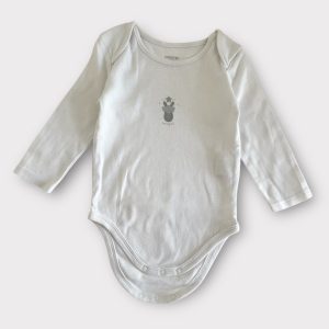 Body bébé blanc à manches longues avec fermeture à pressions et un motif sur le devant. Seconde main.