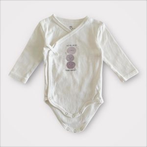 Body bébé blanc cassé à manches longues avec ouverture croisée et motif central lie-de-vin. Seconde main