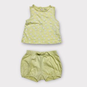 Ensemble bébé jaune citron composé d’un haut sans manches à fleurs blanches et d’un short assorti. Seconde main.