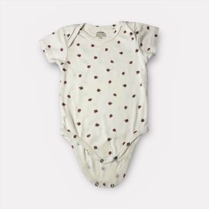 Body bébé blanc à manches courtes avec motifs coccinelles, fermeture à pressions à l’entrejambe. Seconde main.