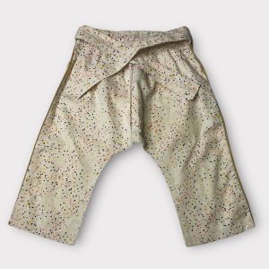Pantalon pour bébé beige à pois multicolores, coupe ample avec taille ceinturée et finitions dorées sur les côtés. Seconde main.