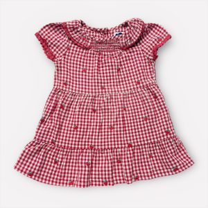 Robe bébé vichy rouge et blanche à manches courtes, ornée de petits motifs fraises, avec volants et smocks décoratifs. Seconde main.