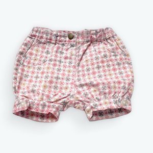 Short bébé fond blanc avec des motifs graphiques roses gris répétés, poches décoratives taille élastiquée fronces au bas. Seconde main.