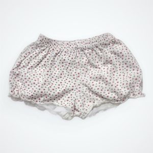 Short bébé fond blanc avec un imprimé répété floral, élastiqué à la taille. Seconde main.