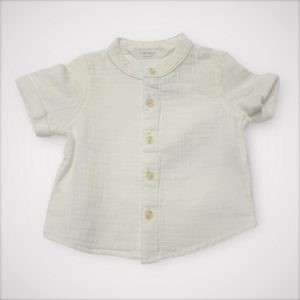 Chemise bébé blanche à manches courtes avec petit col, et tissu gaufré. Seconde main.