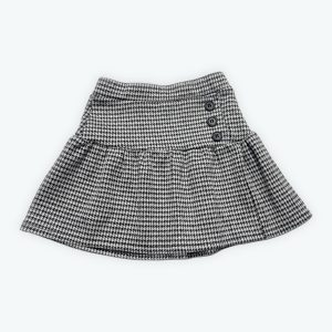 Jupe enfant pied de poule noir et blanc élastiquée à la taille patte de boutons décoratifs. Seconde main.