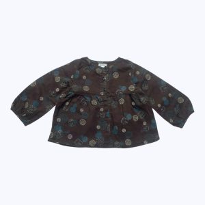 Blouse bébé manches longues froncées aux poignets, chocolat avec des motifs crème et bleu canard. Ouverture centrale devant. Seconde main.