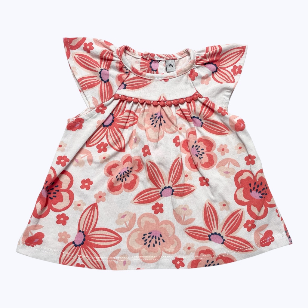 Tunique bébé manches courtes blanches motifs floral coloré patte de boutonnage au dos. Seconde main.