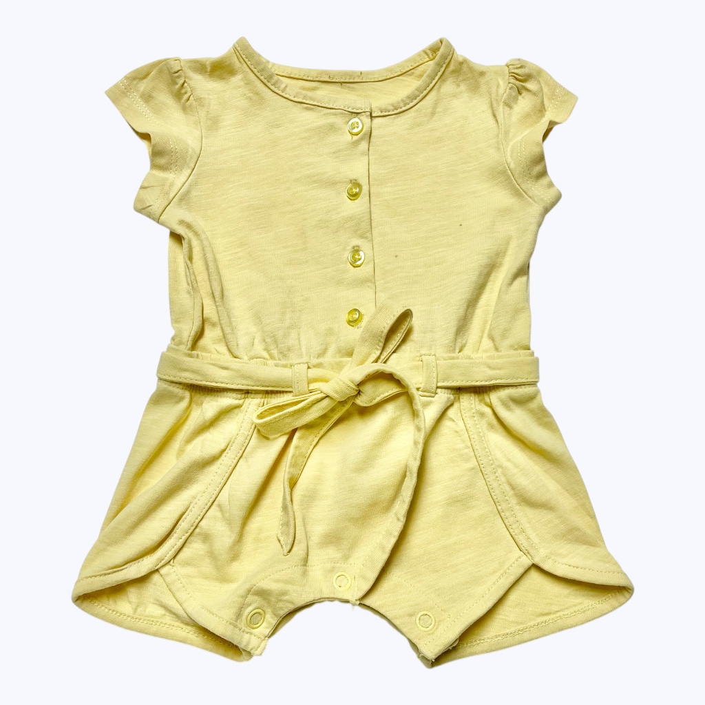 Combishort bébé jaune, patte de boutonnage devant, ceinture à la taille. Seconde main.